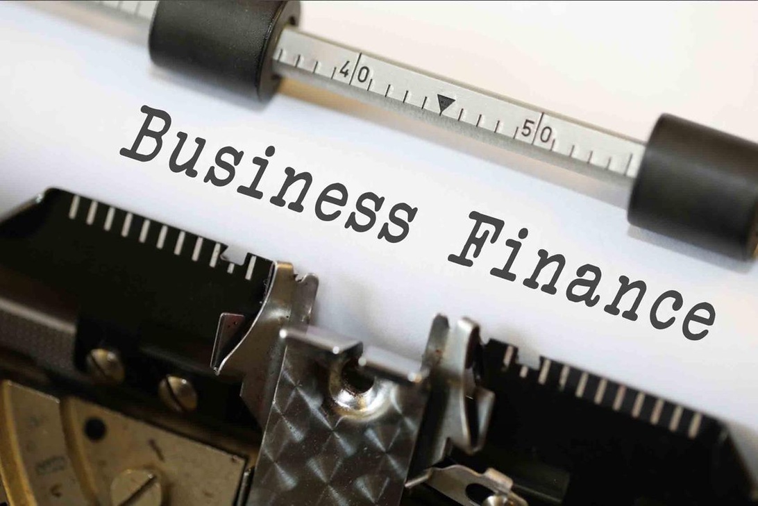 En närbild av en äldre skrivmaskin med ett papper som visar texten 'Business Finance'. Bilden är tydlig och professionellt komponerad och representerar konceptet företagsekonomi på ett kreativt och visuellt tilltalande sätt.